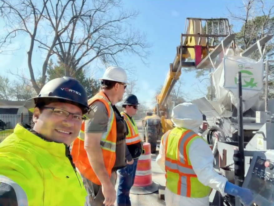 Vortex crew members in hard hats and hi-vis vests on site beside GeoKrete application equipment.